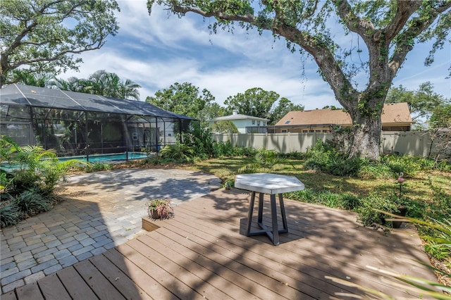 13785 Oak Forest Blvd S, Seminole, FL 33776 - wooden deck featuring a fenced backyard, glass enclosure, and an outdoor pool