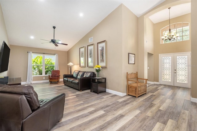 living room with visible vents, ceiling fan with notable chandelier, french doors, and light wood-style flooring