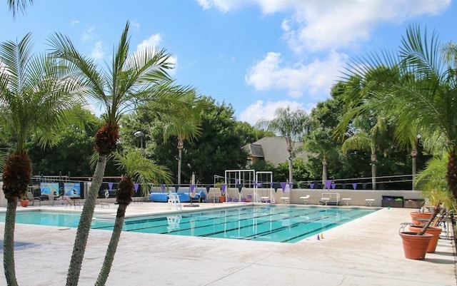community pool with fence and a patio