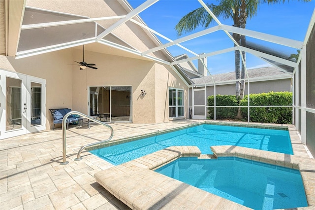 view of pool featuring ceiling fan, a patio, glass enclosure, a pool with connected hot tub, and french doors