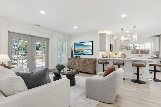 living room with recessed lighting, french doors, and light wood-type flooring