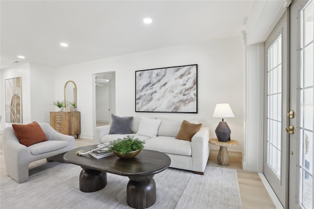 living room with recessed lighting, a wealth of natural light, and light wood-style flooring