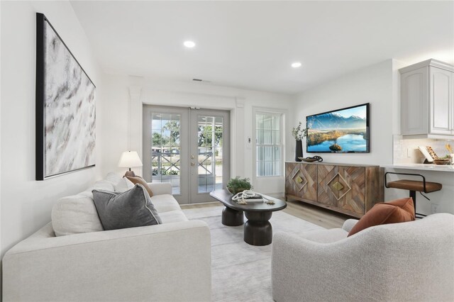 living area with french doors, light wood-type flooring, recessed lighting, and visible vents