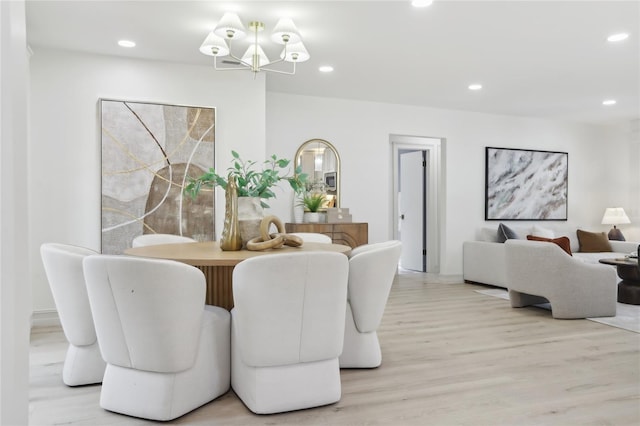 dining area with light wood-style flooring, recessed lighting, and a notable chandelier