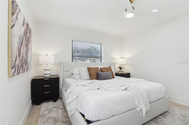 bedroom with light wood finished floors, ceiling fan, and baseboards
