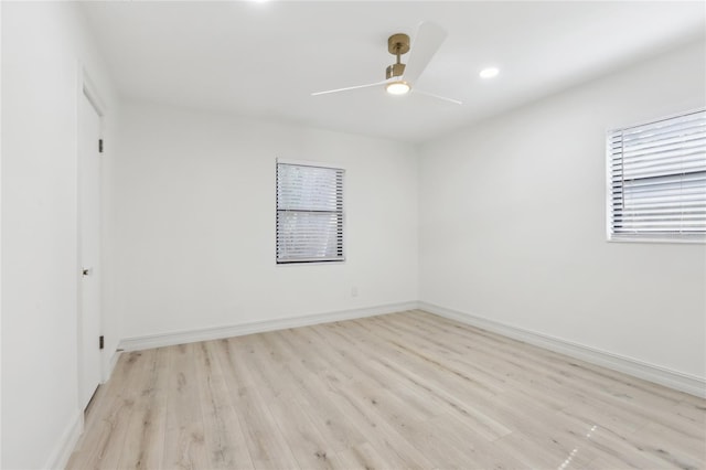 spare room with light wood-type flooring, a ceiling fan, recessed lighting, and baseboards