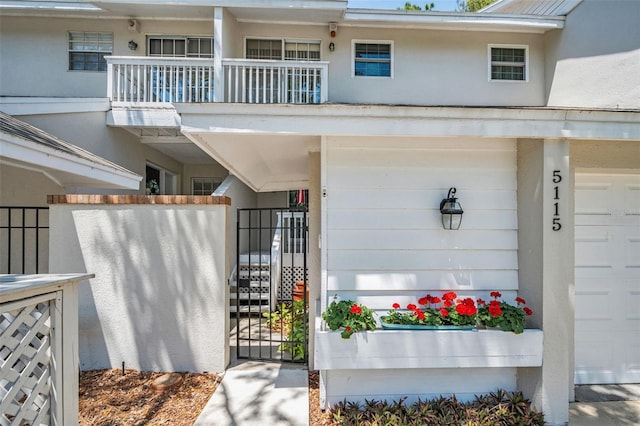 5115 S Jules Verne Ct, Tampa, FL 33611 - property entrance with a balcony, fence, stucco siding, and a gate