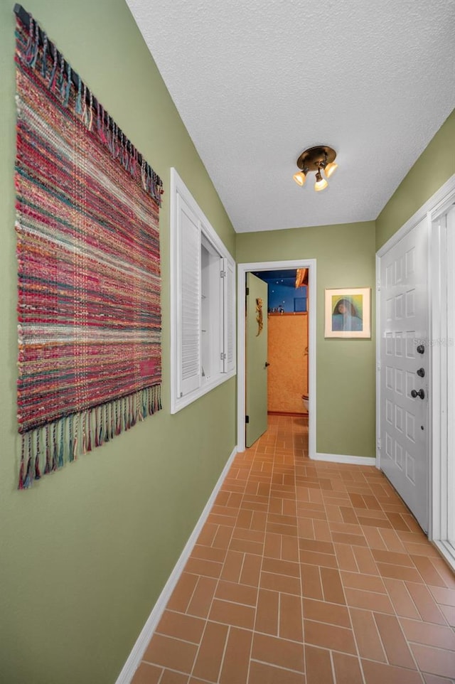 5115 S Jules Verne Ct, Tampa, FL 33611 - corridor featuring a textured ceiling, brick patterned floor, and baseboards