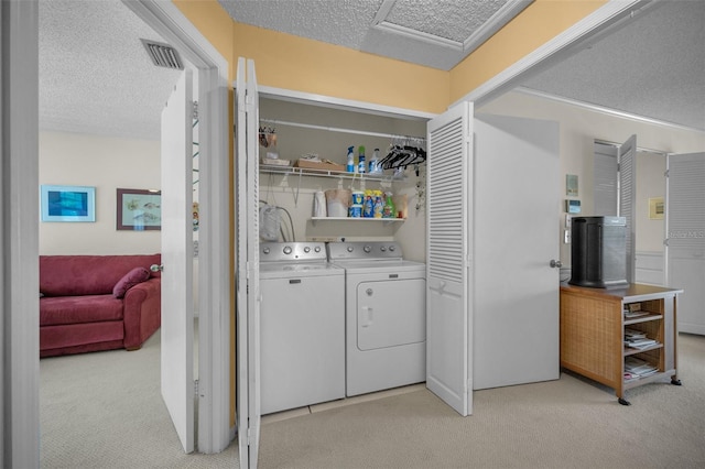 5115 S Jules Verne Ct, Tampa, FL 33611 - laundry area featuring a textured ceiling, washing machine and clothes dryer, light colored carpet, visible vents, and laundry area