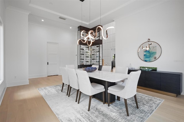 dining area featuring light wood-style flooring, visible vents, a notable chandelier, and a tray ceiling