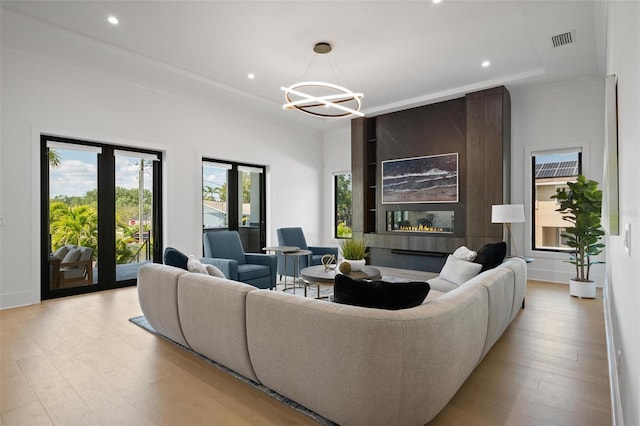 living room featuring an inviting chandelier, light wood-style flooring, visible vents, and recessed lighting