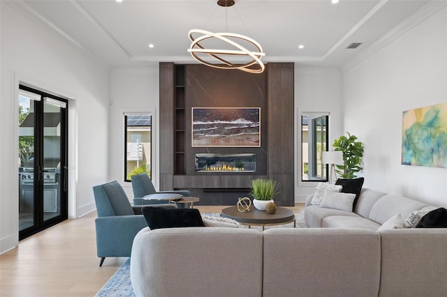living area with light wood-type flooring, plenty of natural light, recessed lighting, and a chandelier