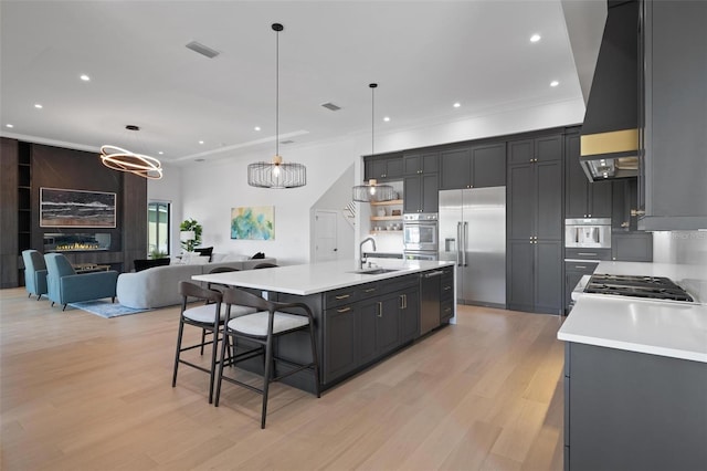 kitchen featuring a sink, light wood-type flooring, recessed lighting, light countertops, and appliances with stainless steel finishes