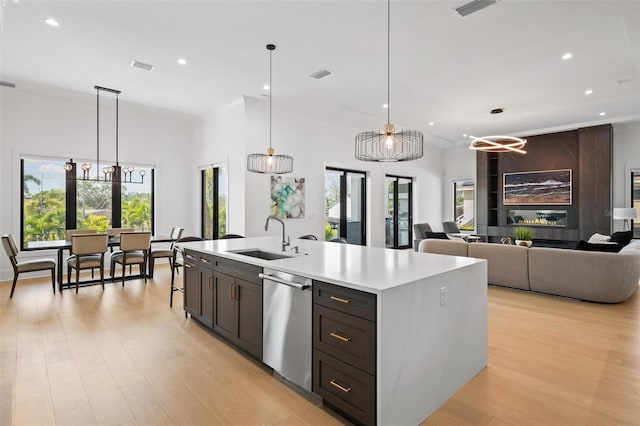 kitchen featuring dishwasher, light countertops, a sink, and recessed lighting