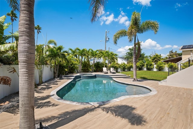 view of pool with a fenced backyard, a yard, and a pool with connected hot tub