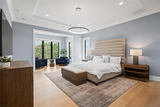bedroom featuring light wood-type flooring, a raised ceiling, baseboards, visible vents, and recessed lighting