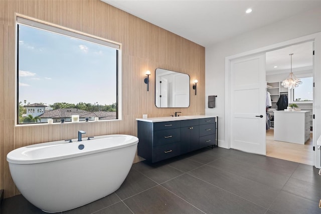 full bathroom with vanity, tile patterned flooring, a chandelier, and a freestanding bath