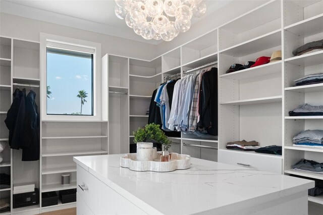 spacious closet with an inviting chandelier