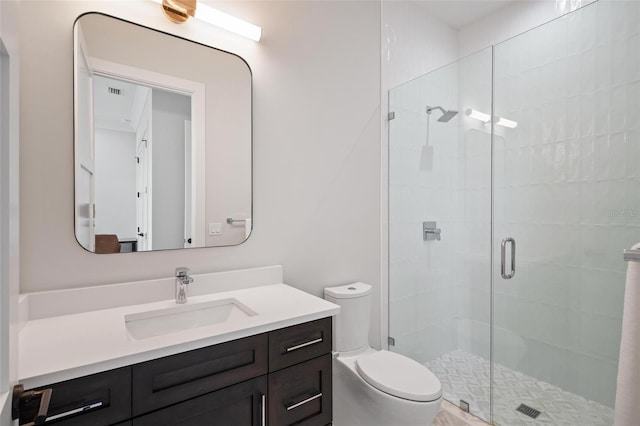 bathroom with toilet, vanity, and a stall shower