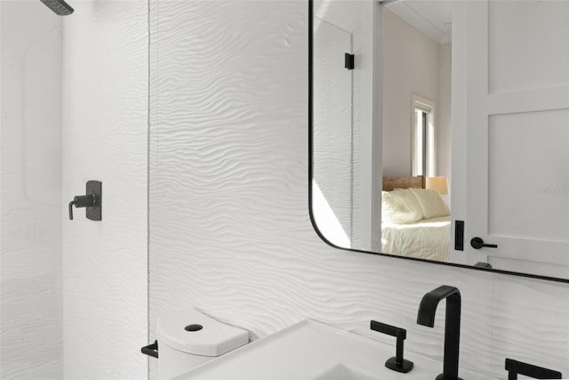 bathroom with ensuite bath, toilet, and a sink