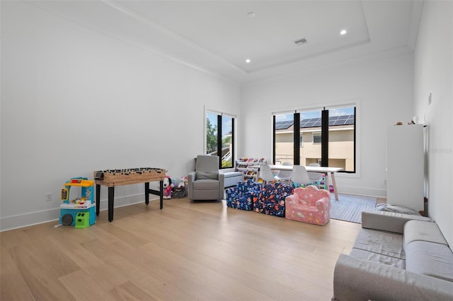living room with recessed lighting, a tray ceiling, wood finished floors, visible vents, and baseboards