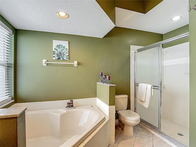 bathroom with a textured wall, a garden tub, and a wealth of natural light