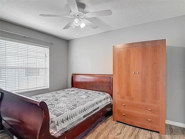 bedroom with wood finished floors, a textured ceiling, and ceiling fan