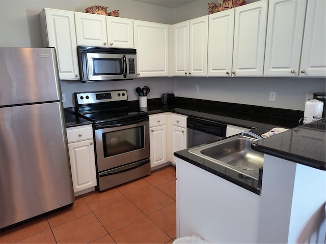 kitchen with white cabinets, stainless steel appliances, and dark countertops