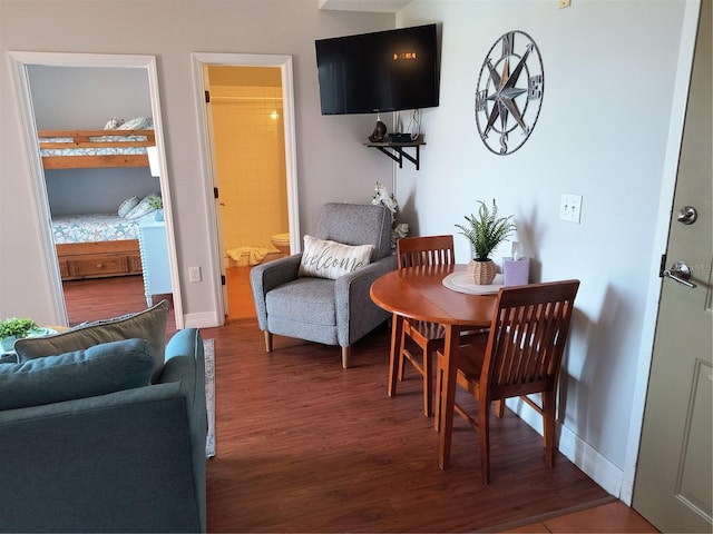 dining area with baseboards and wood finished floors