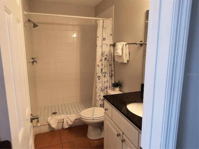 bathroom featuring tile patterned flooring, vanity, toilet, and a shower stall
