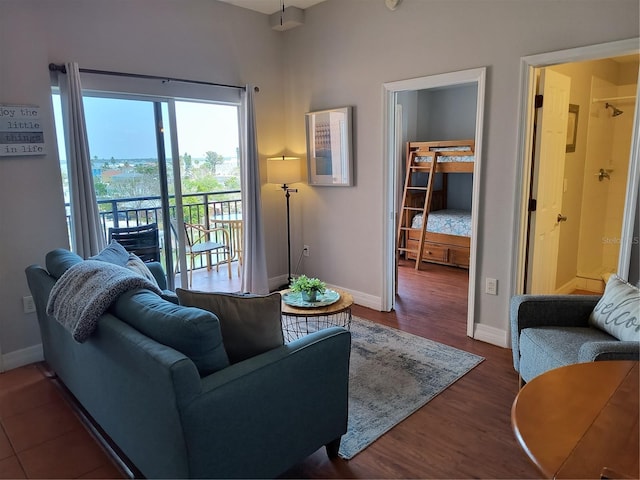 living room with baseboards and dark wood-type flooring