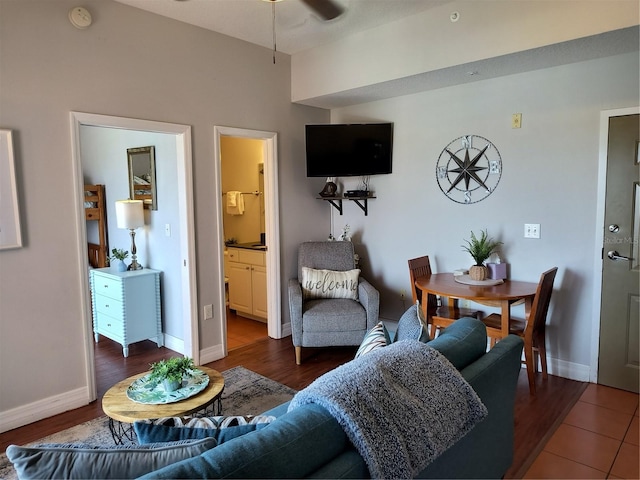 living room featuring baseboards, a ceiling fan, and dark wood-style flooring