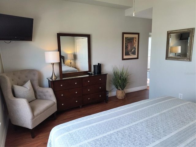 bedroom with dark wood-style flooring and baseboards