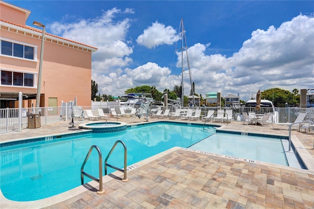 pool featuring a patio, fence, and a community hot tub