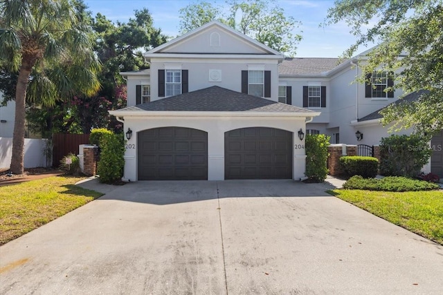 view of front of house with stucco siding, central AC unit, fence, and concrete driveway