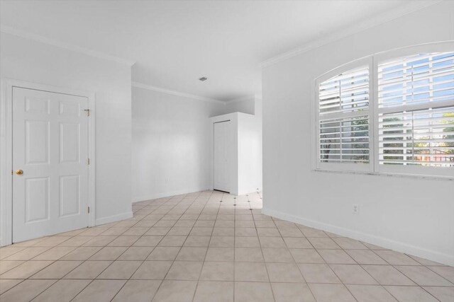 empty room with crown molding and baseboards