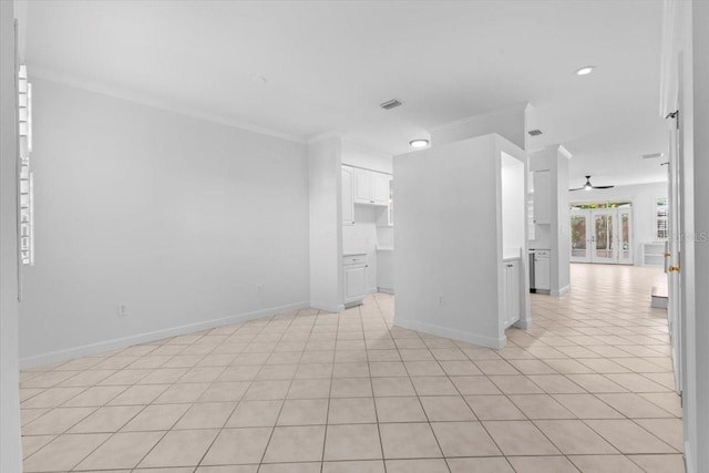 unfurnished room with visible vents, ornamental molding, baseboards, a ceiling fan, and light tile patterned floors