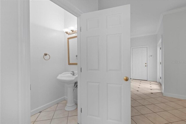 bathroom with baseboards, ornamental molding, and tile patterned floors