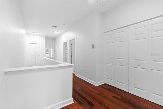 corridor with baseboards and dark wood finished floors