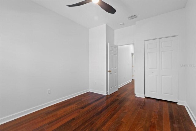 unfurnished bedroom with ceiling fan, baseboards, wood finished floors, visible vents, and a closet