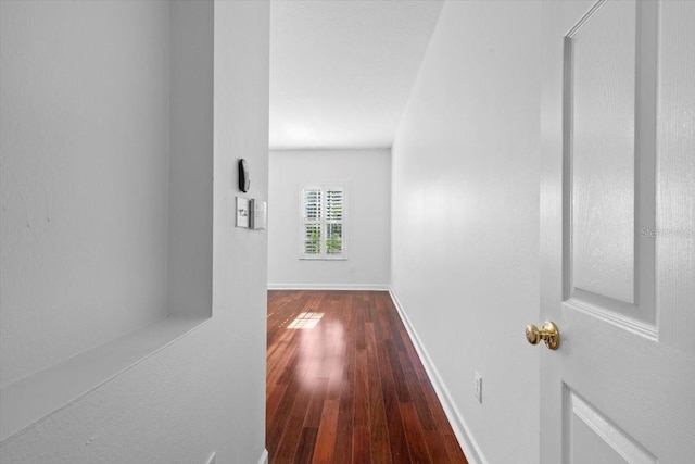 hallway with wood-type flooring and baseboards