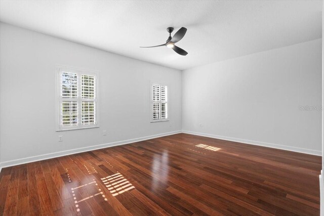 empty room with baseboards, a ceiling fan, and wood finished floors