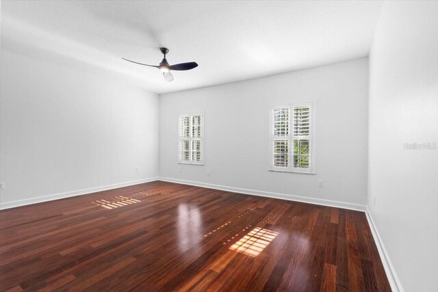 empty room featuring baseboards, a ceiling fan, and wood finished floors