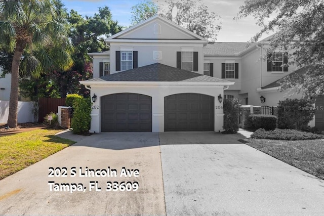 202 S Lincoln Ave, Tampa, FL 33609 - neoclassical home with driveway, a garage, and stucco siding