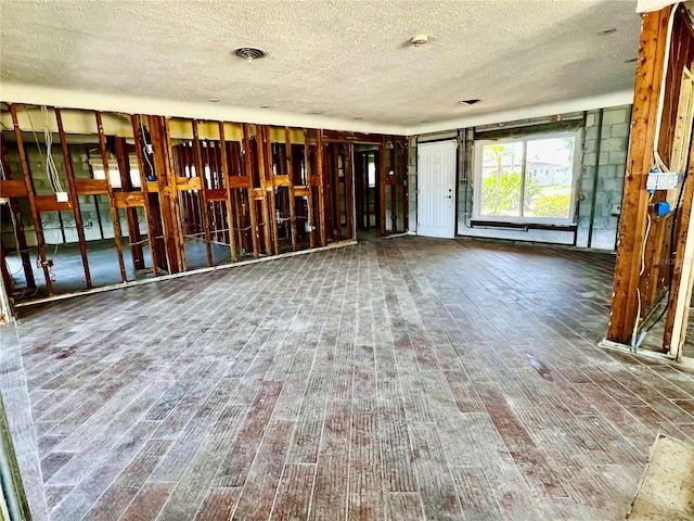 interior space featuring visible vents, a textured ceiling, and wood finished floors