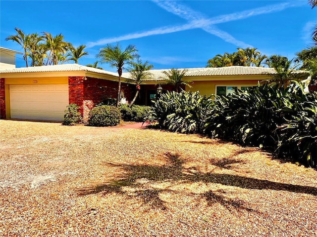view of front of house with an attached garage and a tile roof
