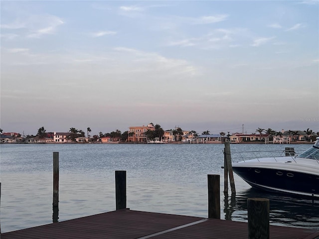 view of dock with a residential view and a water view
