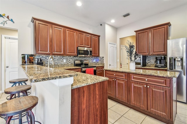1939 Heartland Cir, Valrico, FL 33594 - kitchen featuring stainless steel appliances, visible vents, decorative backsplash, and light tile patterned floors