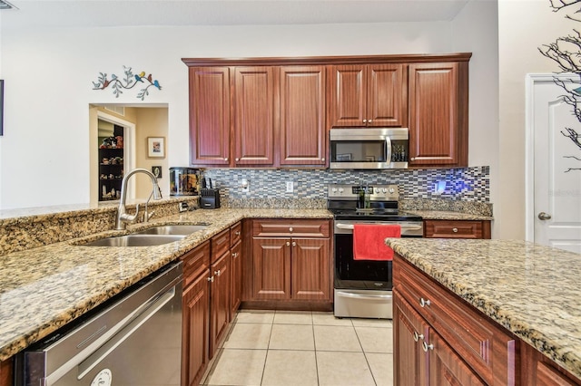 1939 Heartland Cir, Valrico, FL 33594 - kitchen with decorative backsplash, light stone counters, a sink, appliances with stainless steel finishes, and light tile patterned floors