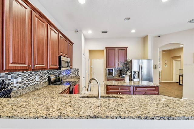 1939 Heartland Cir, Valrico, FL 33594 - kitchen with decorative backsplash, visible vents, appliances with stainless steel finishes, arched walkways, and a sink